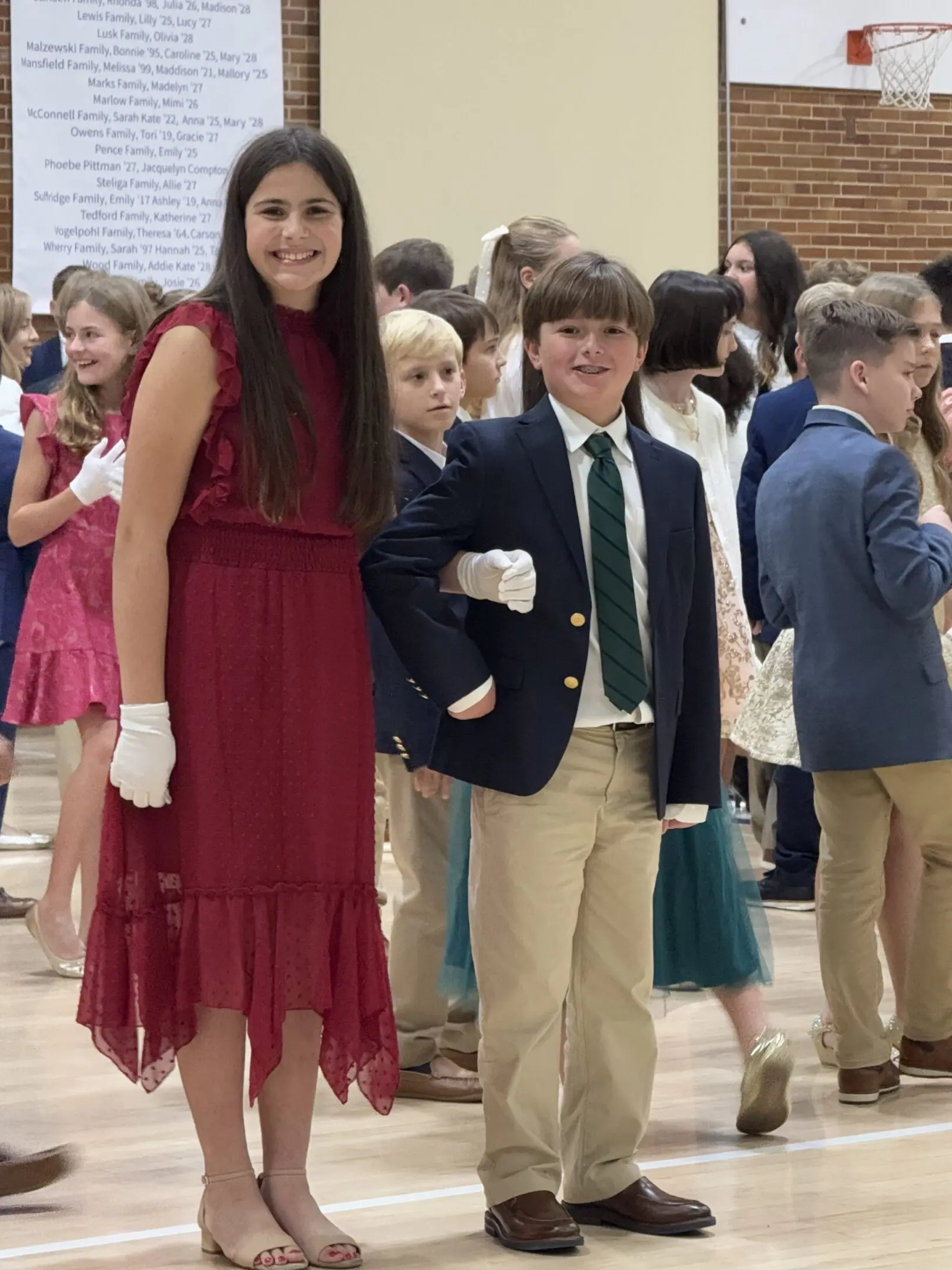 Two formally dressed Little Rock Junior Cotillion students practicing social confidence together
